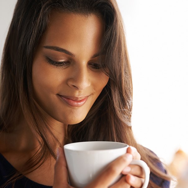 Woman drinking coffee which causes tooth staining
