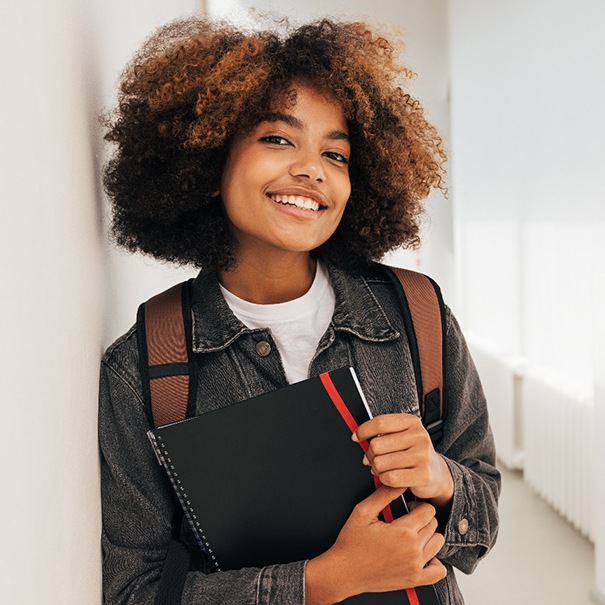 a high schooler holding a notebook