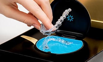 Invisalign aligners being placed in a storage case