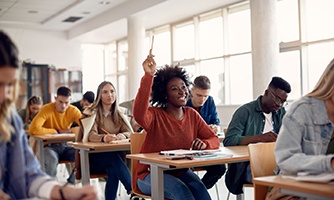 a high school student raising her hand in class