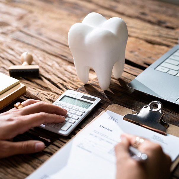 someone at a desk calculating the cost of dental care